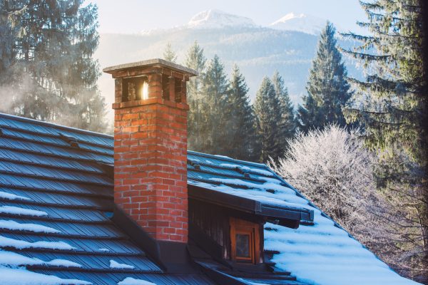 Mountain cottage chimney made of bricks on the roof